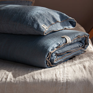 Pie de cama acolchado de lino con funda de almohada a juego.