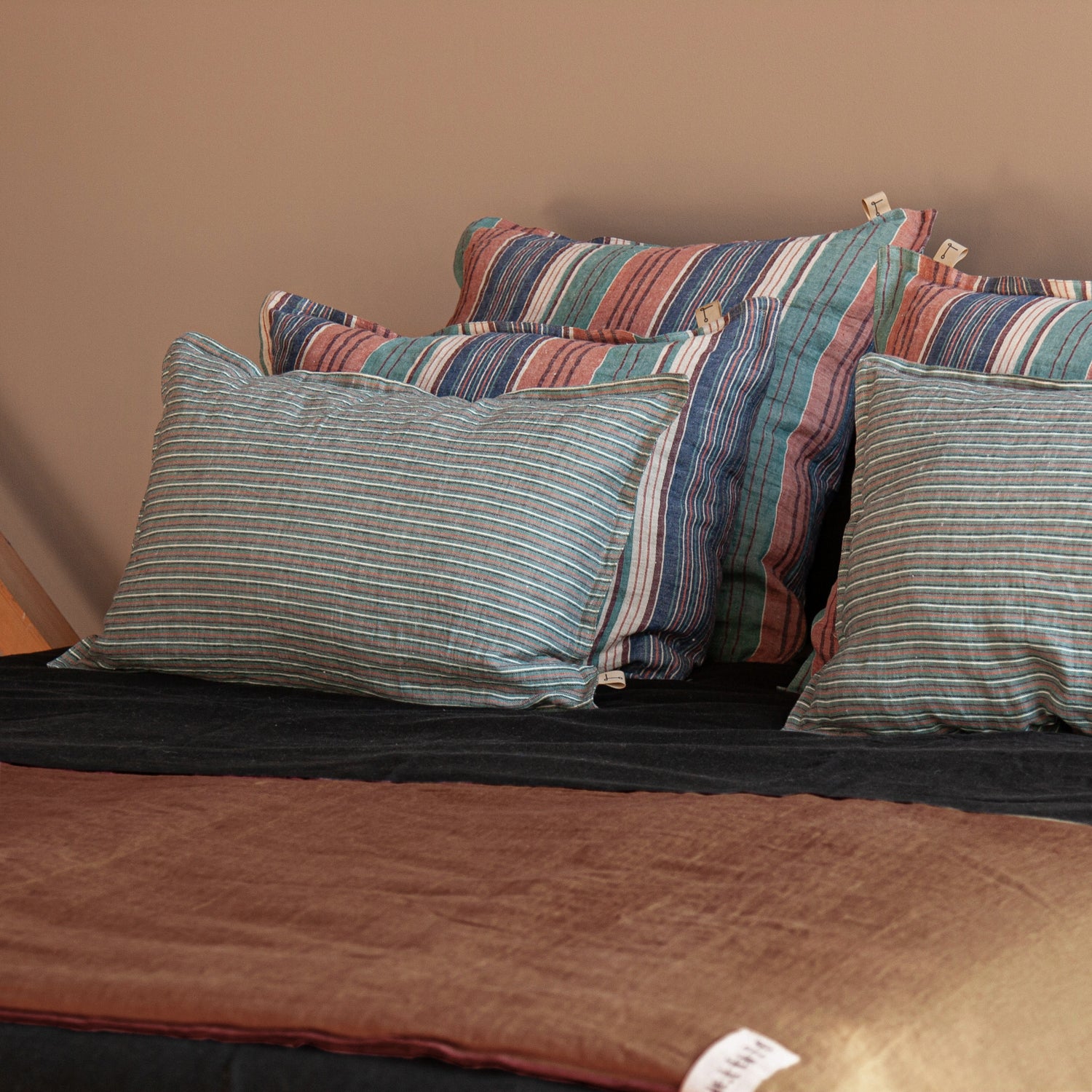 Grupo de cojines y pie de cama de color terracota.