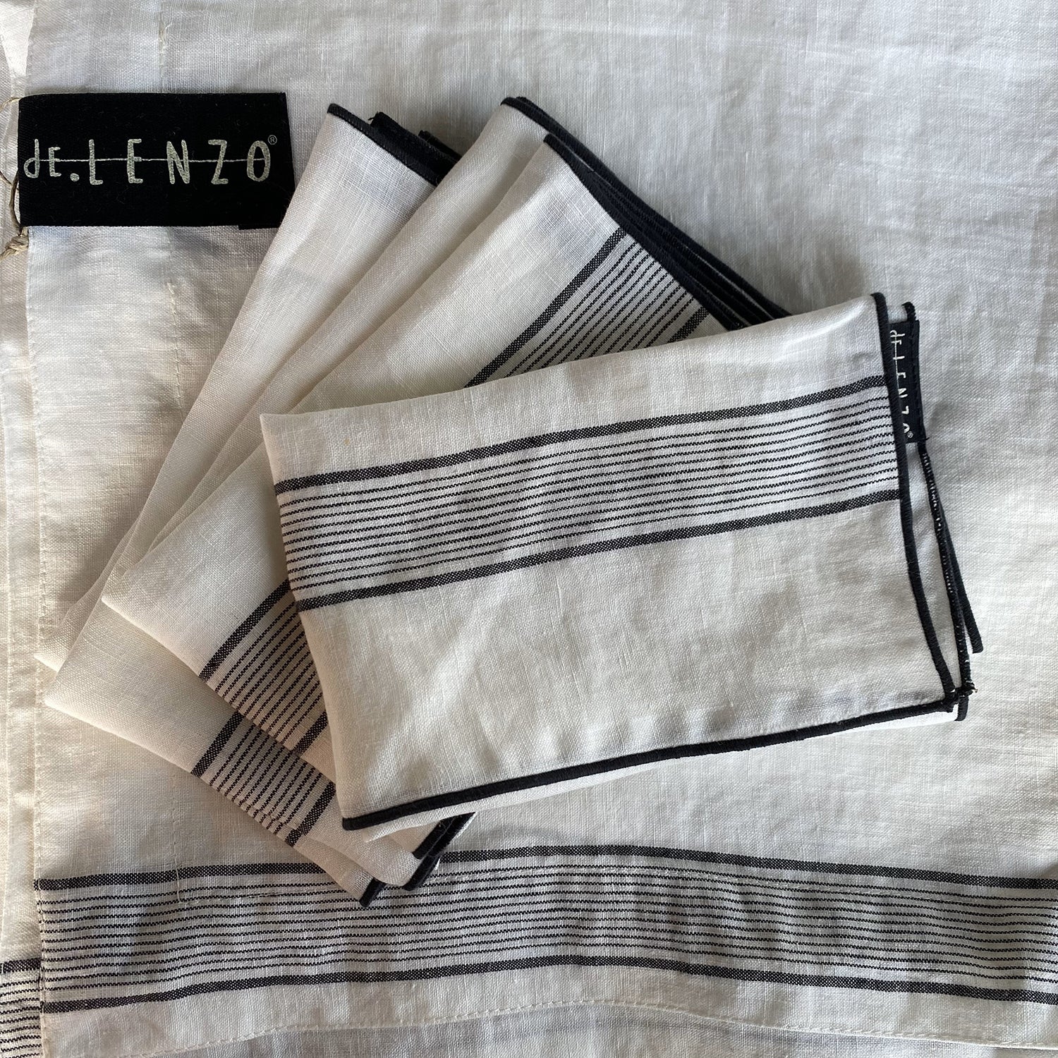 Servilletas de mantel de lino blanco con rayas finas de color negro.