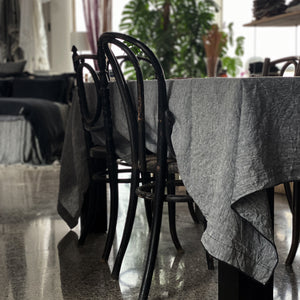 Mantel de lino gris jaspeado con sillas antiguas.