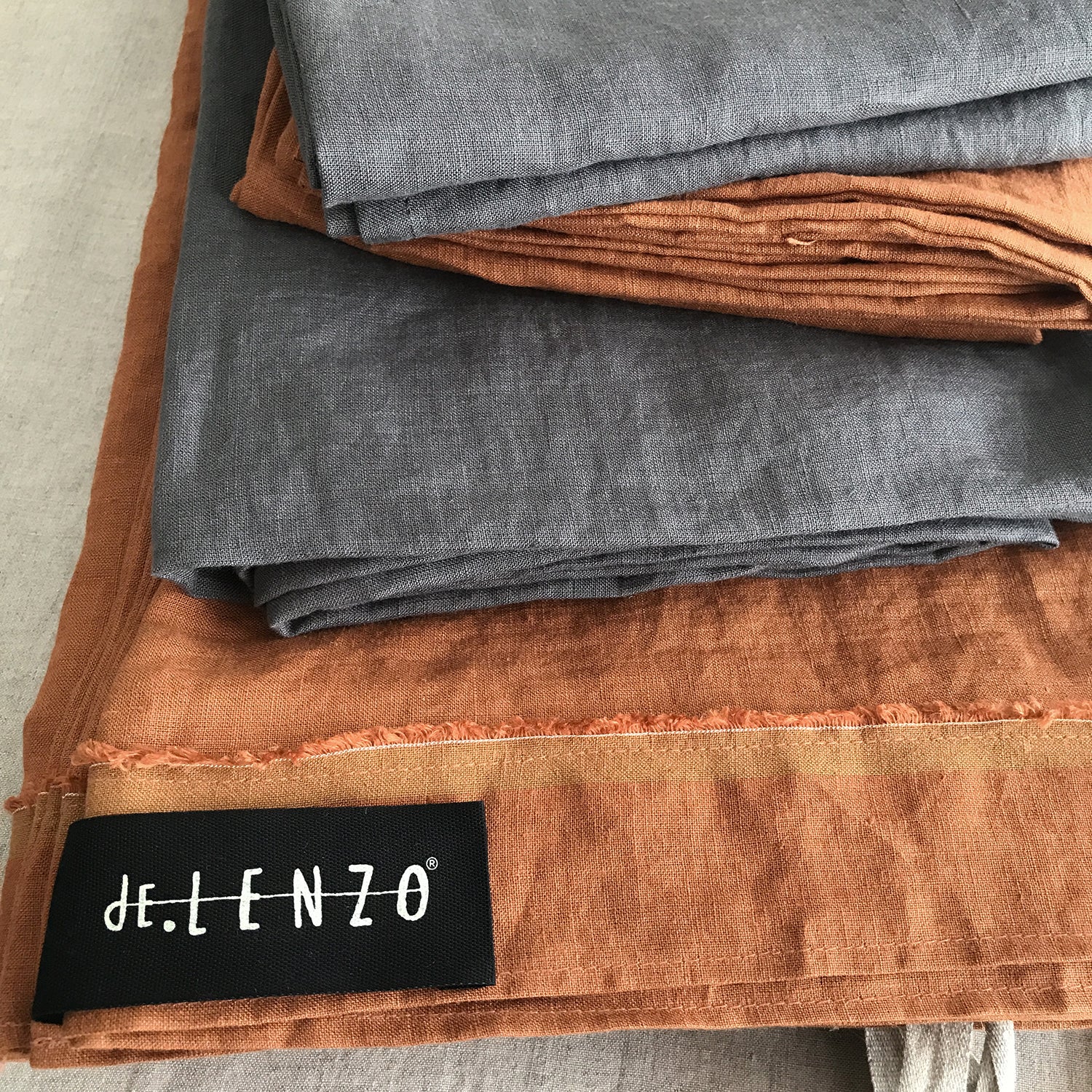 Funda nórdica de lino teja y bajeras grises.