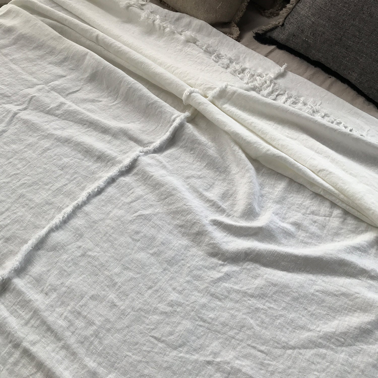 Detalle de Colcha de lino lavado de color blanco desflecado artesanalmente