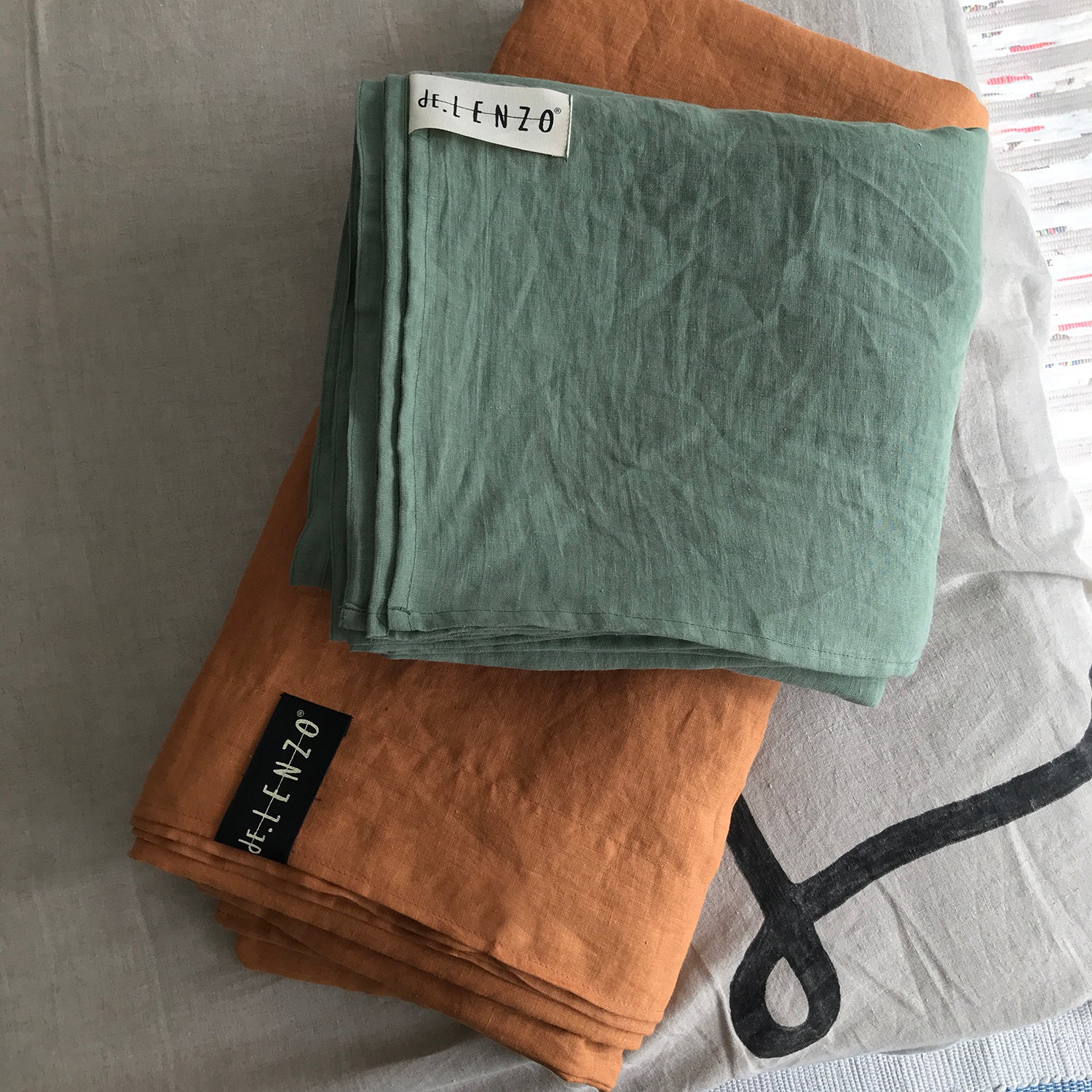 Funda nórdica de lino teja y almohadas verdes.