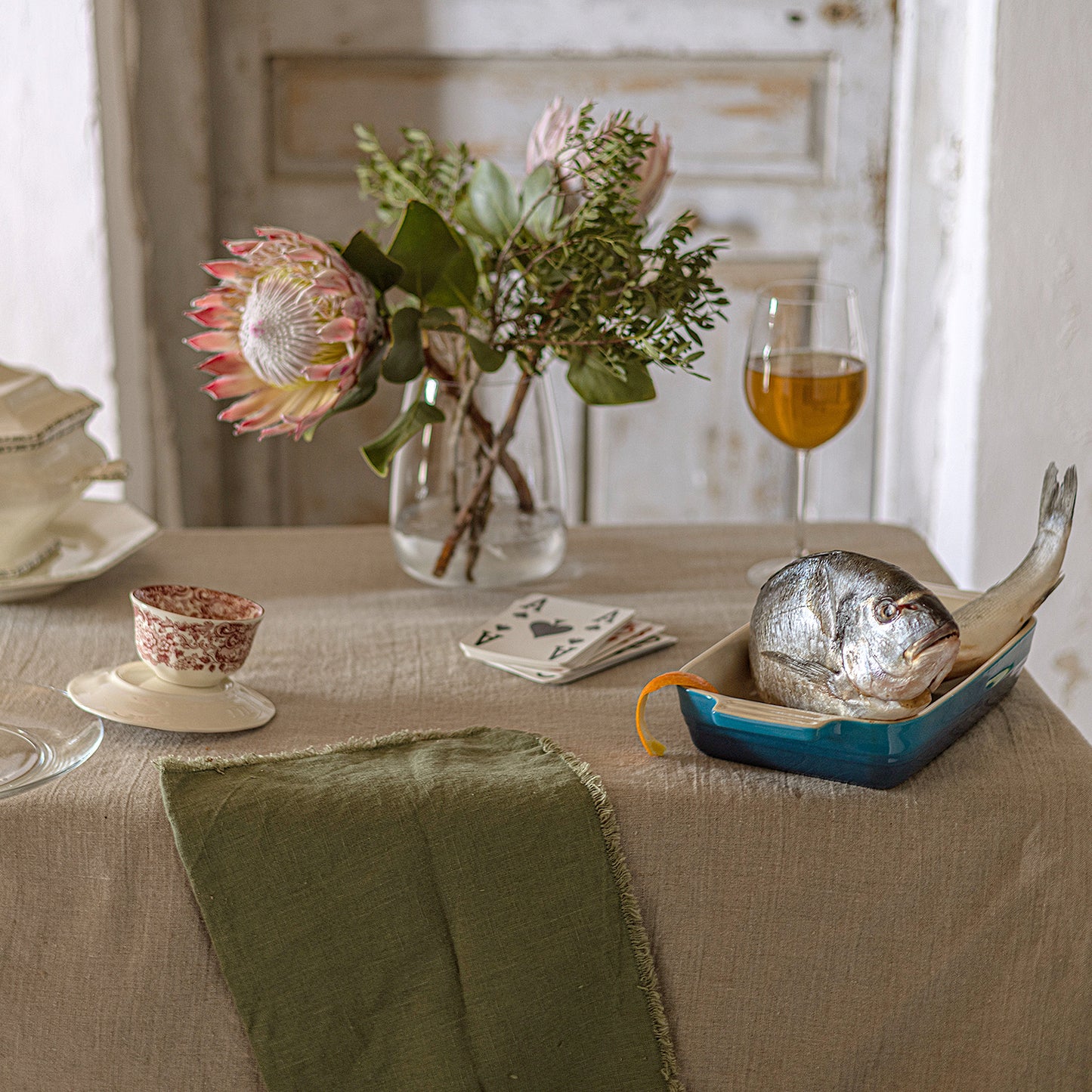 Mantel de lino natural con servilleta verde olivo.