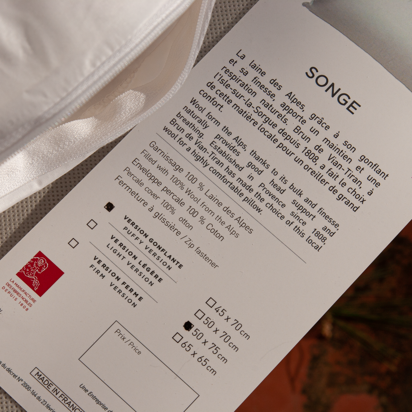 Detalle de la etiqueta oficial Woolmark en almohada de lana de los Alpes dELENZO, garantizando la pureza y calidad de la fibra francesa.