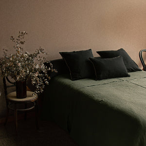 Imagen de colcha de lino verde en habitación del taller de dELENZO