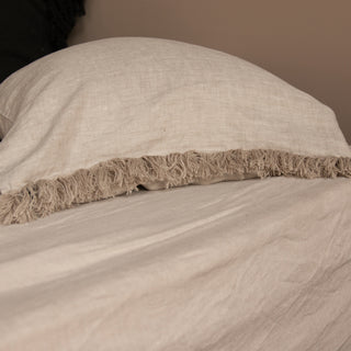 Funda de almohada de lino sobre sábana natural rústica