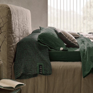 Cama de lino natural con sábanas verdes de lino