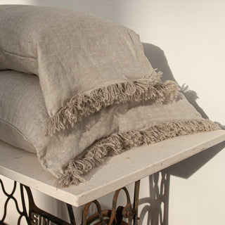 Funda de almohada de lino natural espigado acabada con flecos.