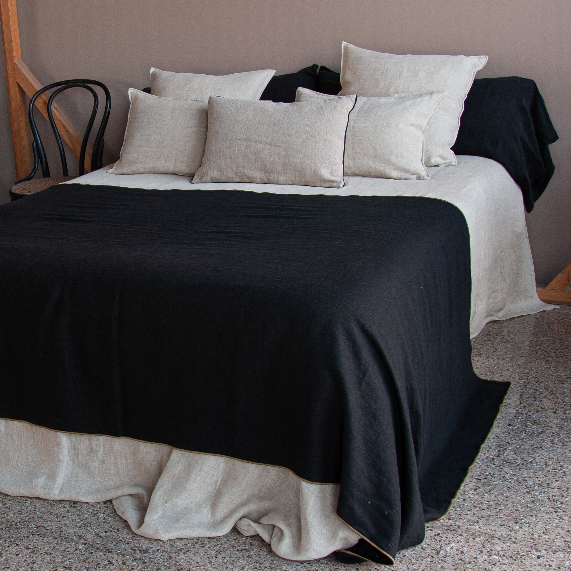 Plaid negro para cama. Con cojines  a juego de lino natural.