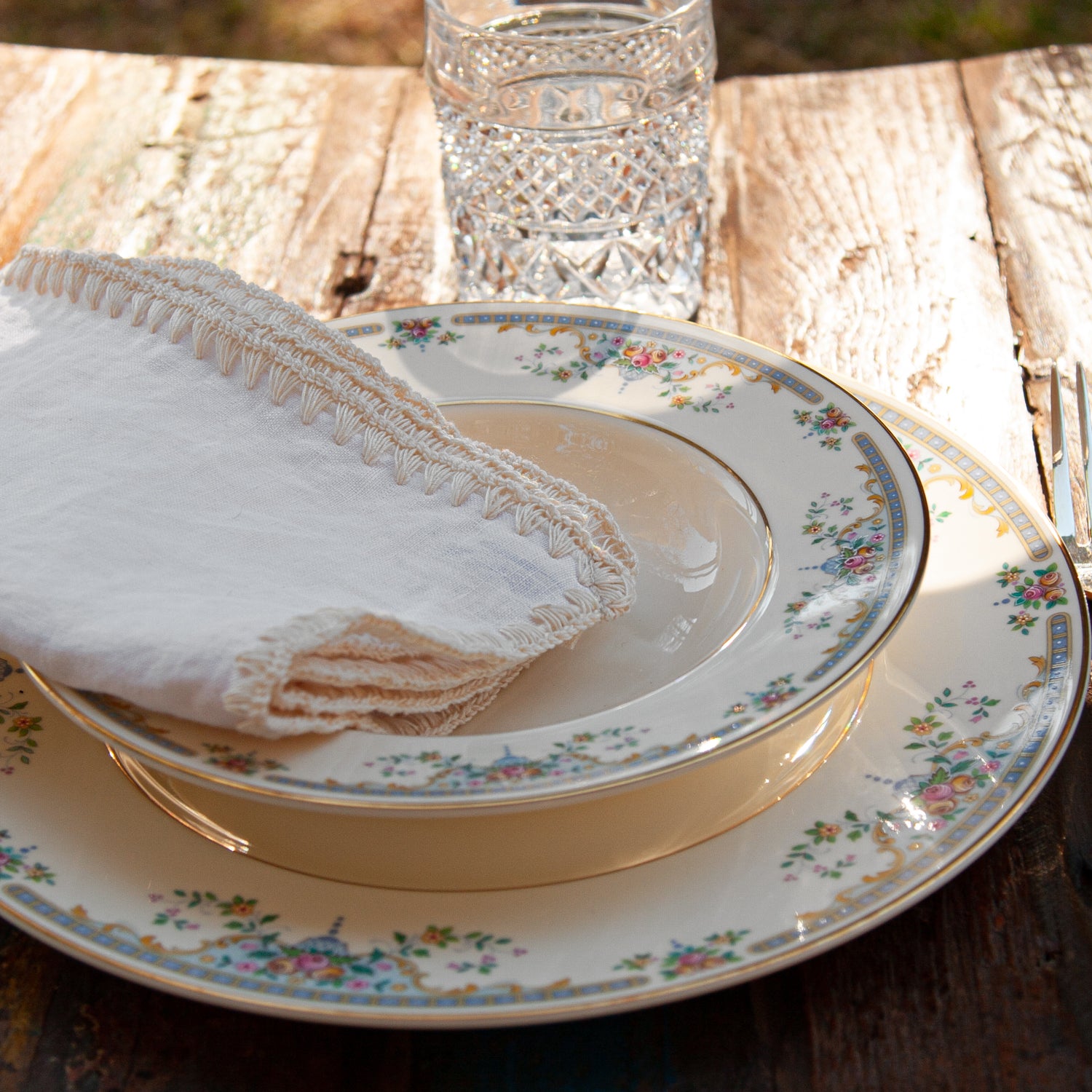 Servilleta de lino blanca con acabado bordado sobre plato de porcelana Alemán.