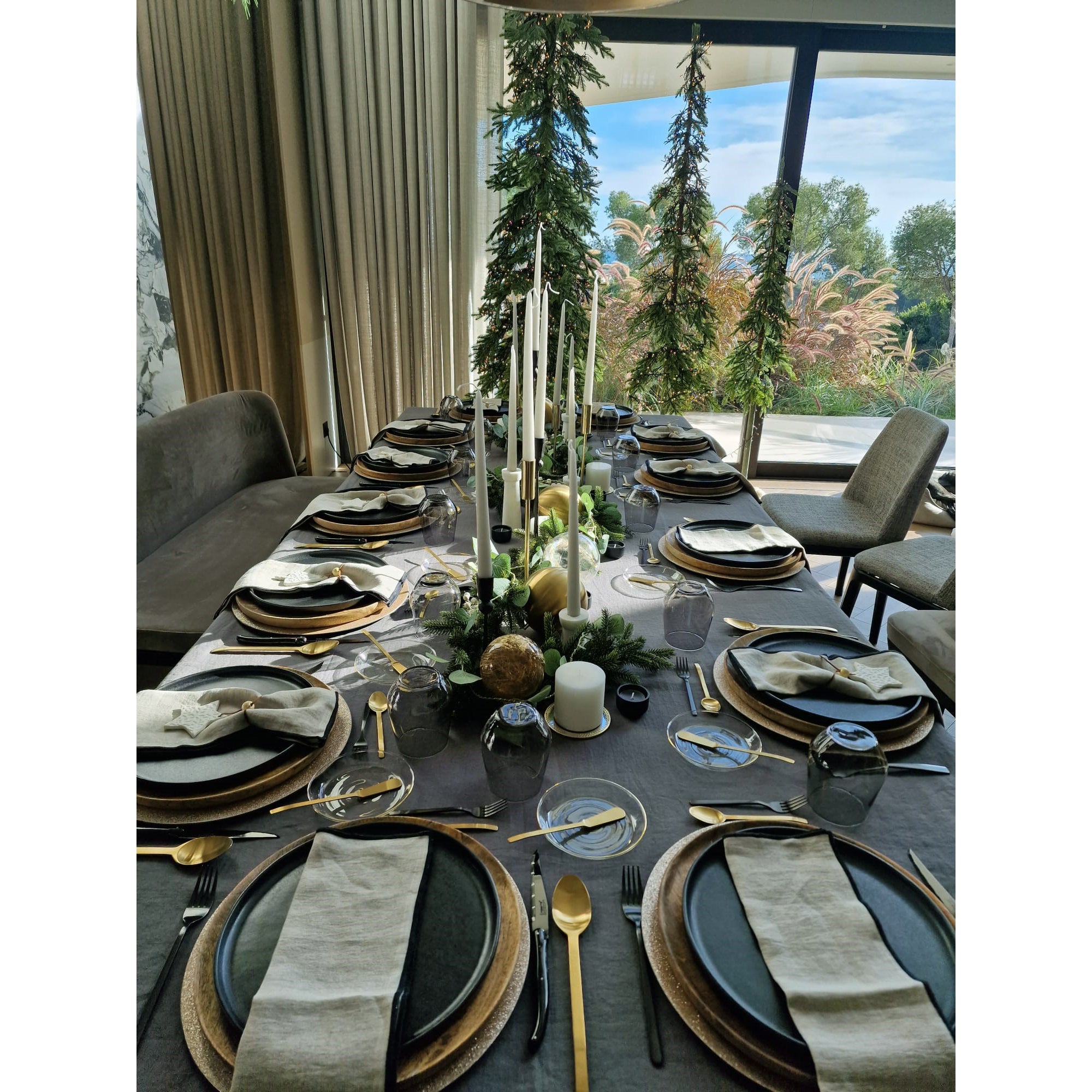 Mesa con platos, servilletas de lino natural y mantel de lino gris.