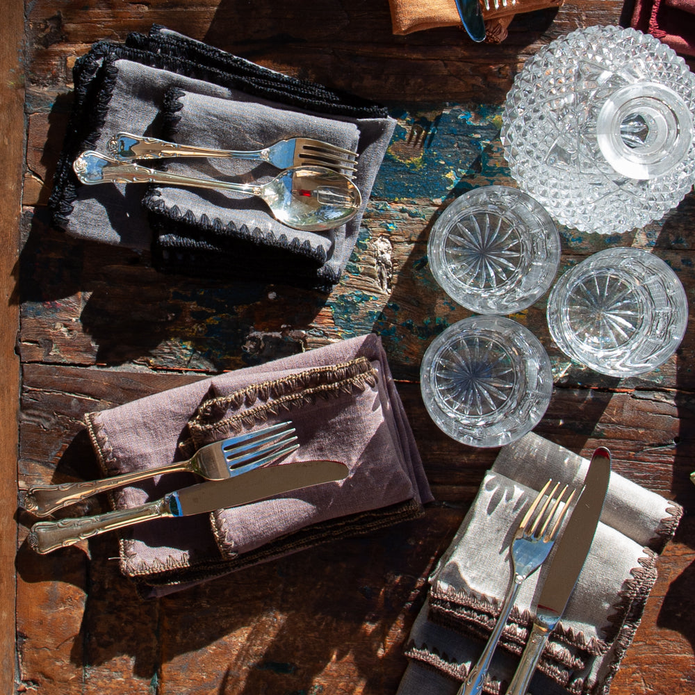 Servilletas de lino con acabado bordado con hilo de algodón. Vasos de cristal de bohemia y mesa de madera reciclada.