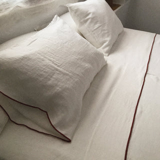 Detalle de sábanas blancas con ribete coral