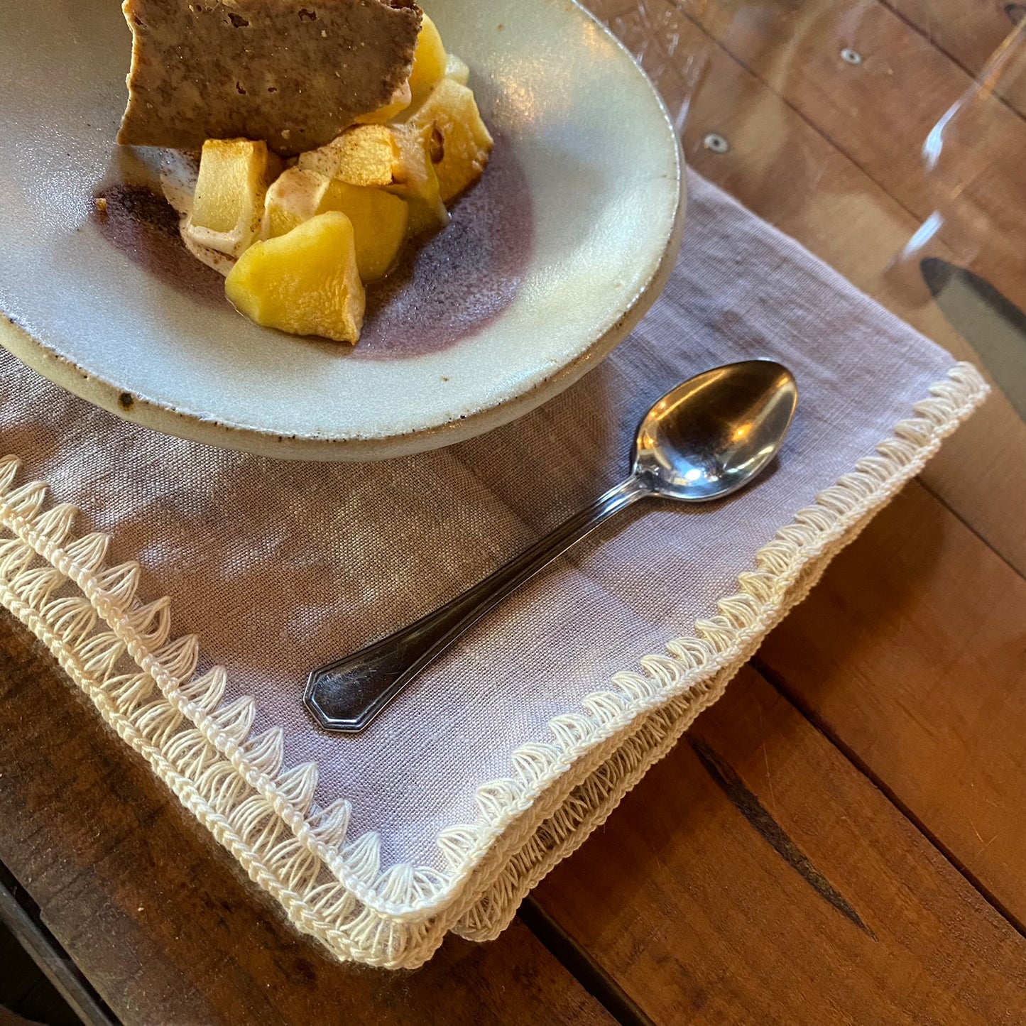 Servilleta malva con postre de manzana en plato de ceramica.