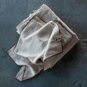 Almohadas de lino natural rústico con repulgo de color marrón.