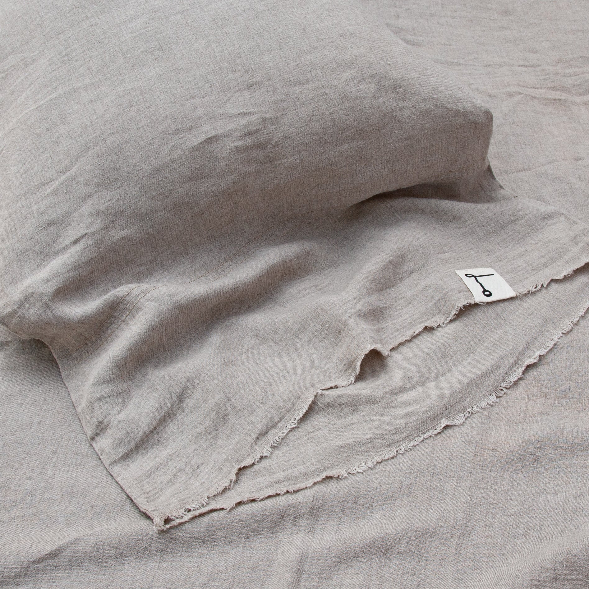 Detalle de almohada de lino natural desflecado.
