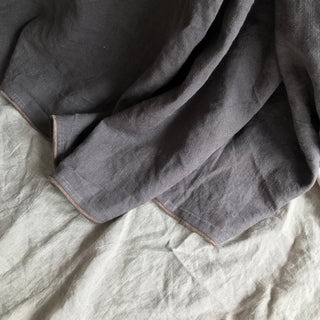 Detalle de Colcha de lino gris con ribete marrón. Estilo clásico