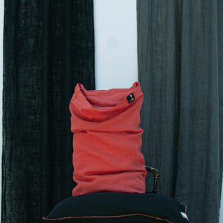 Funda de almohada de lino de color rojo desgastado.