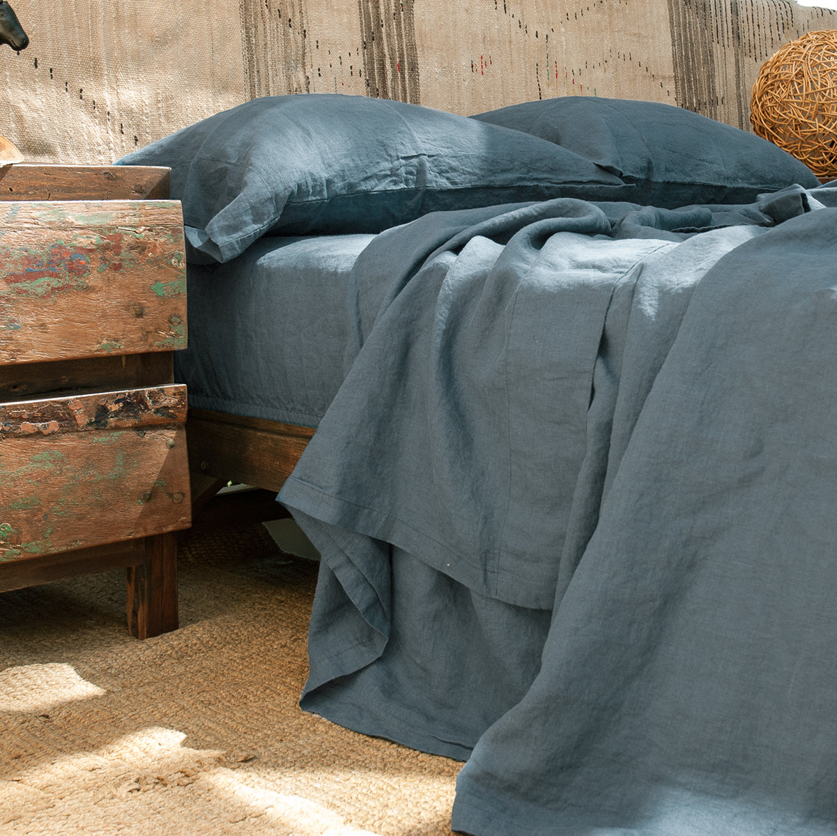 Detalle del juego de sábanas de lino azul. Bajera, encimera y almohadas a juego.