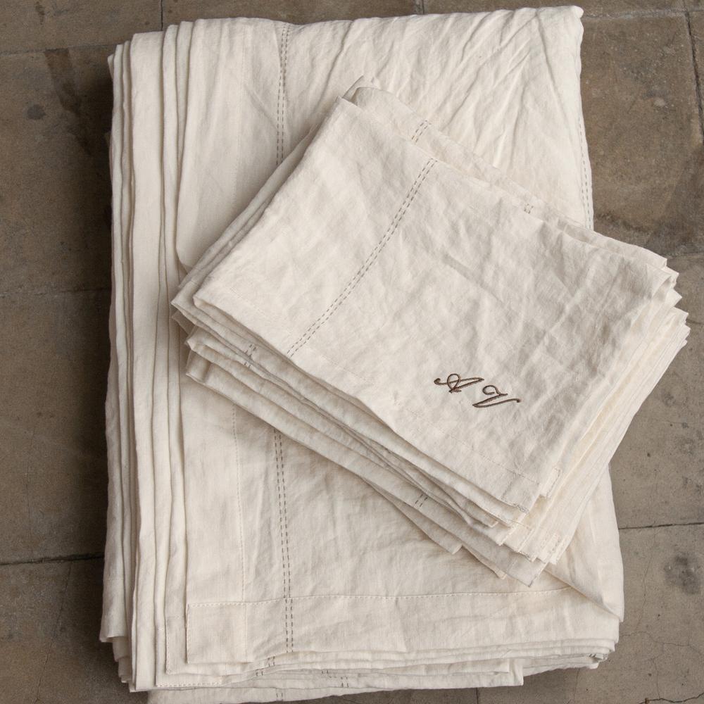 Mantel y servilletas de lino blanco con detalle de hilo natural.
