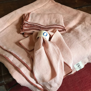 Mantel de lino rosa con servilletas con vivo teja.