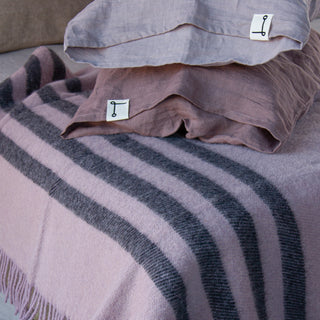 Manta rayada de color rosa de lana virgen.