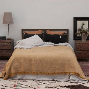 Colcha para pie de cama de lino lavado de color mostaza y sábanas naturales