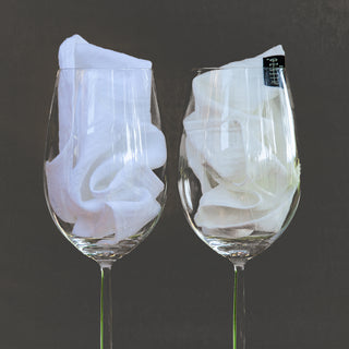 Dos copas de vino con servilletas de lino. Lino blanco óptico y lino blanco roto.