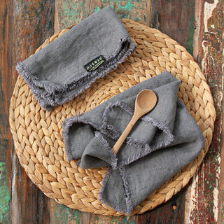 Detalle de servilletas desflecadas grises de lino.