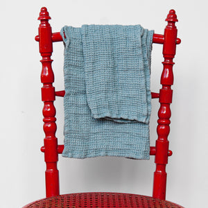 Toallas de lino azul en silla de color rojo. detalle del lino.