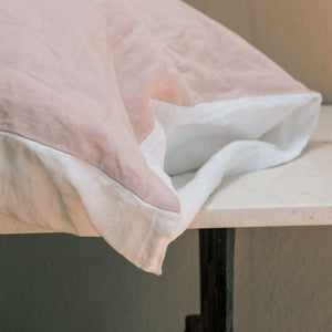 Detalle de almohada de lino rosa y blanco