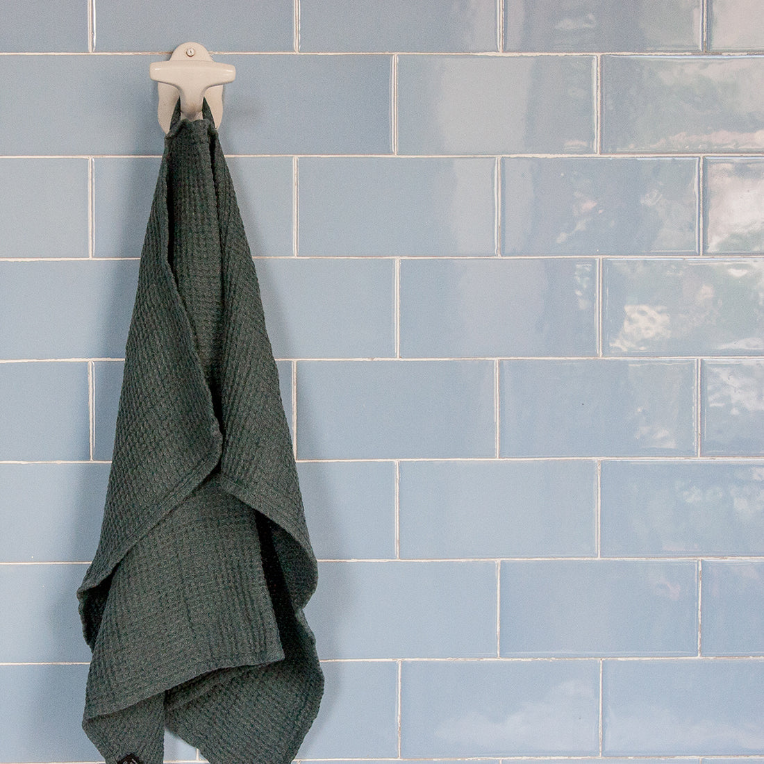 Una toalla de baño de lino gofre de color gris musgo.