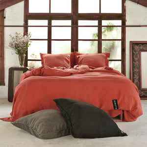 Funda de almohadas de lino de color rojo desgastado.