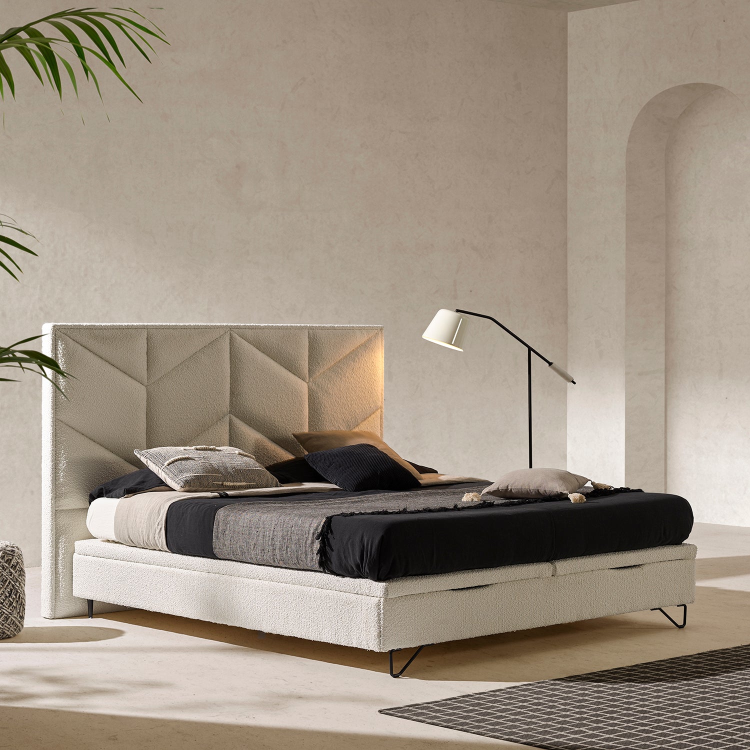 Cama moderna y minimalista con juego de cama de lino negro y plaid jaspeado.