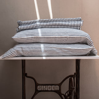 Almohadas y funda nórdica de lino rayado en azul y blanco.