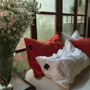 Almohadas de lino combinadas en rojo y blanco.