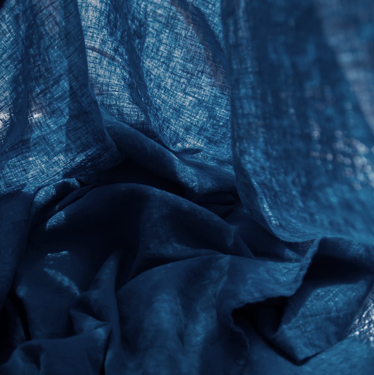 Detalle de la sábana encimera de lino azul mar.