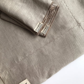 Detalle de servilleta y mantel de lino natural con detalles bordados.