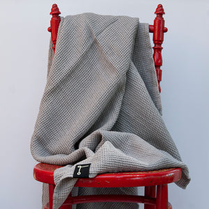 Detalle de toalla de lino gris con forma de panal de abeja. dE.LENZO