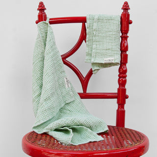 Detalle de dos toallas de lino verde. Con dibujo gofre.